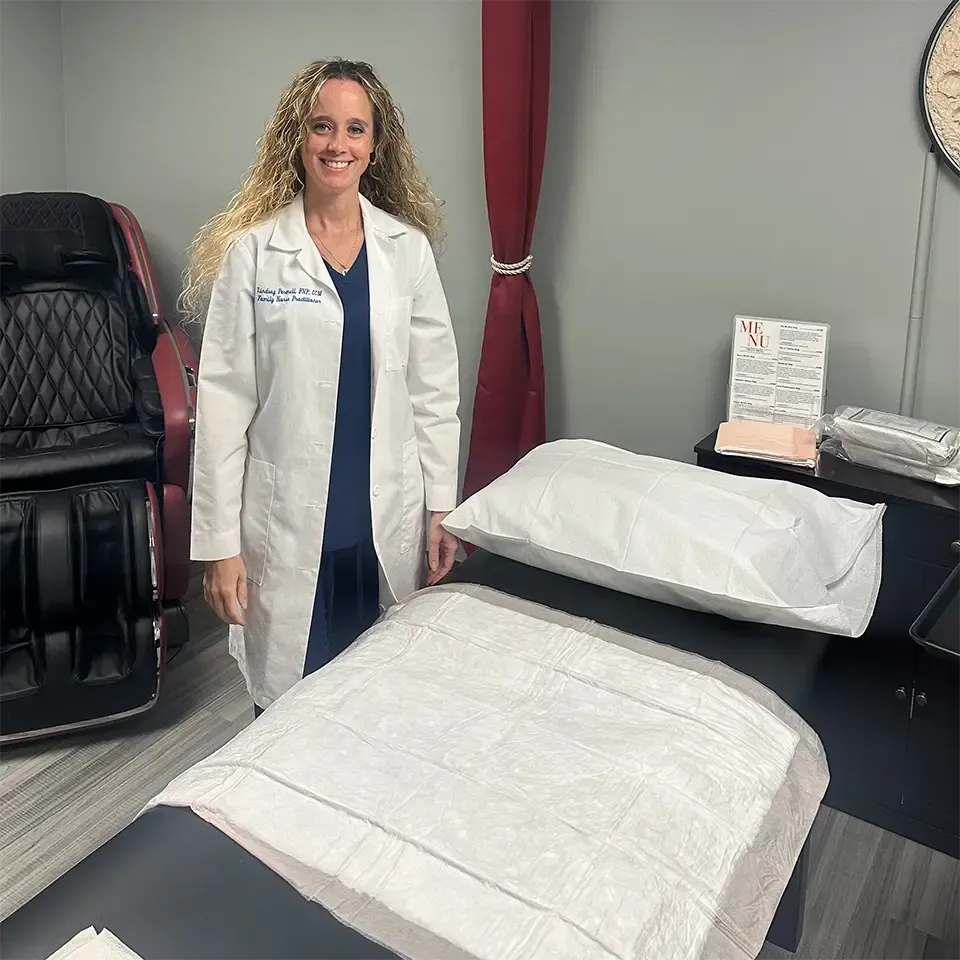 LPN standing next to a bed in a hormone replacement therapy treatment room